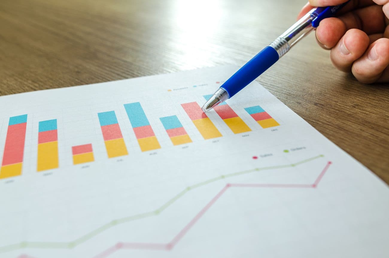 Pen pointing at an upward revenue chart