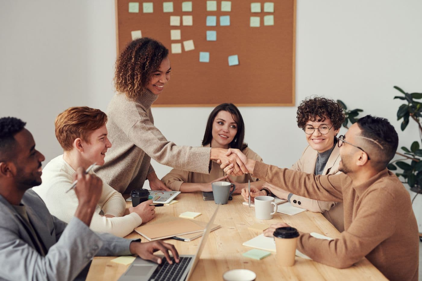 Healthcare consultants shaking hands with a client during a strategy meeting