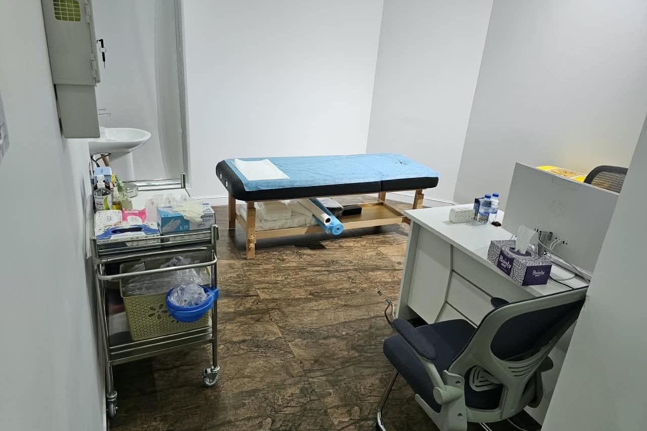 Second cupping treatment room with couch, trolley and hand basin in a medical centre in Abu Dhabi