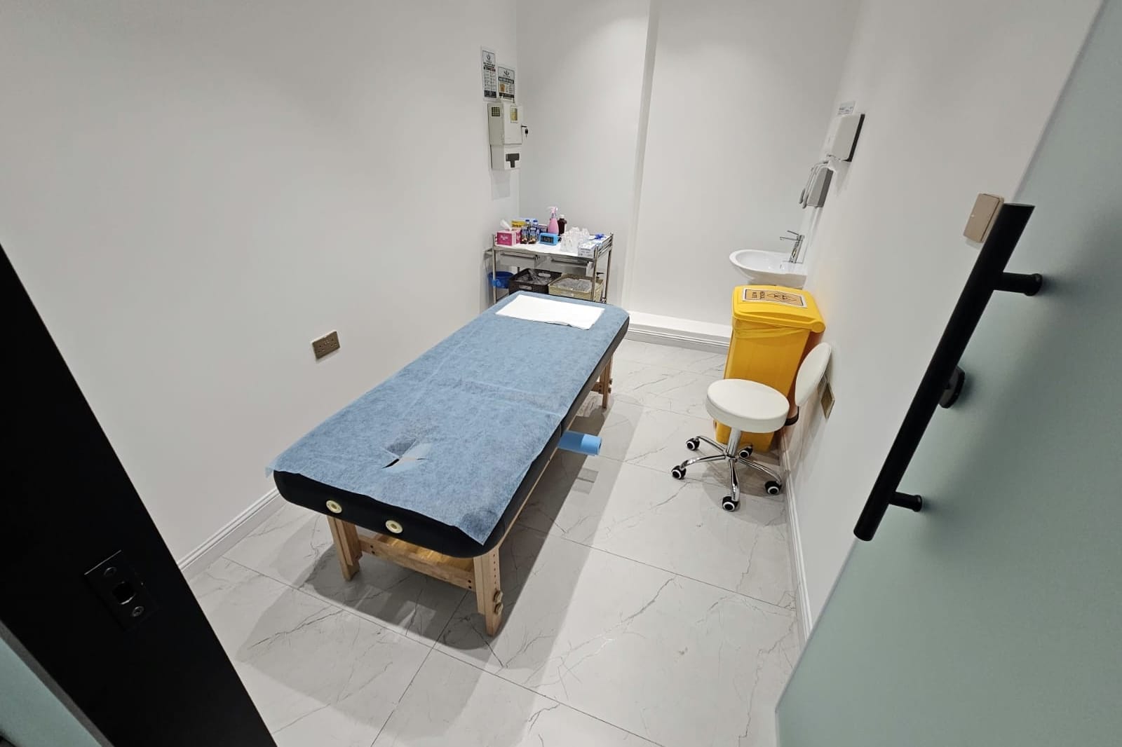 Medical cupping treatment room with couch and supply trolley in a medical centre in Al Danah, Abu Dhabi